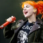 Hayley Williams singing into a red microphone on stage